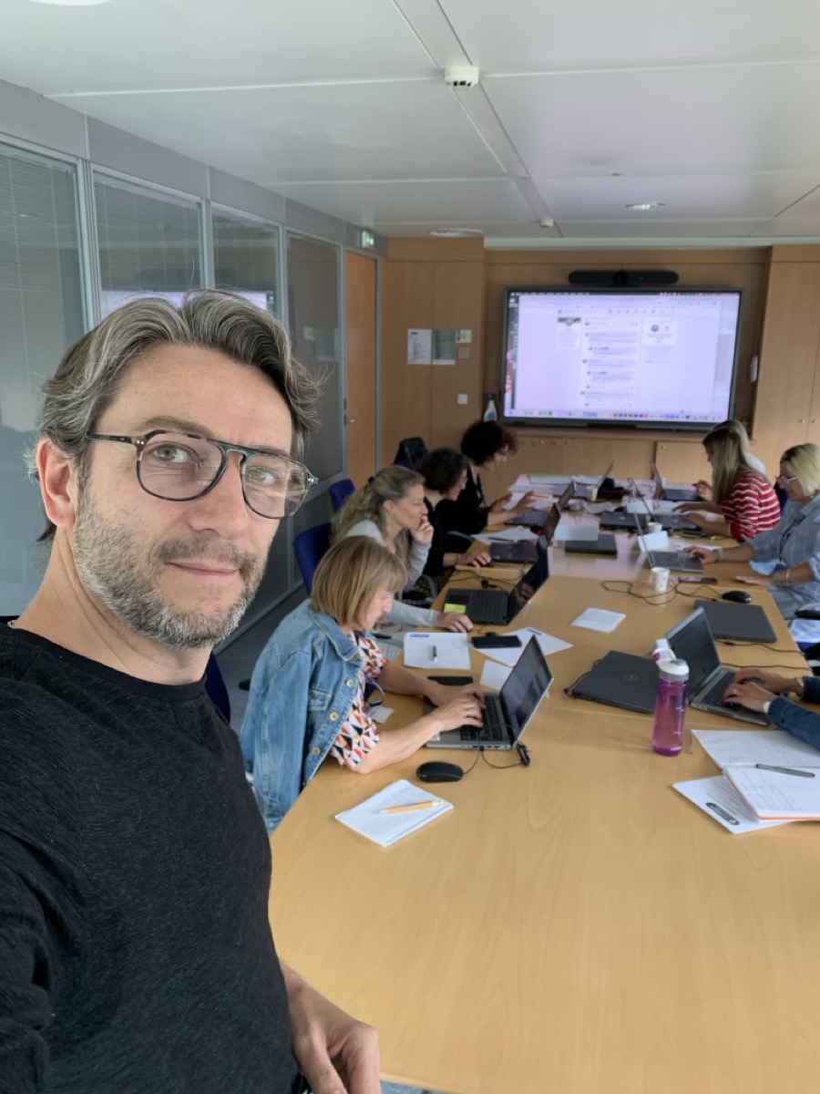 Cyril Marie - Formation IA participative Selfie de Cyril Marie avec un groupe de participants travaillant sur des ordinateurs